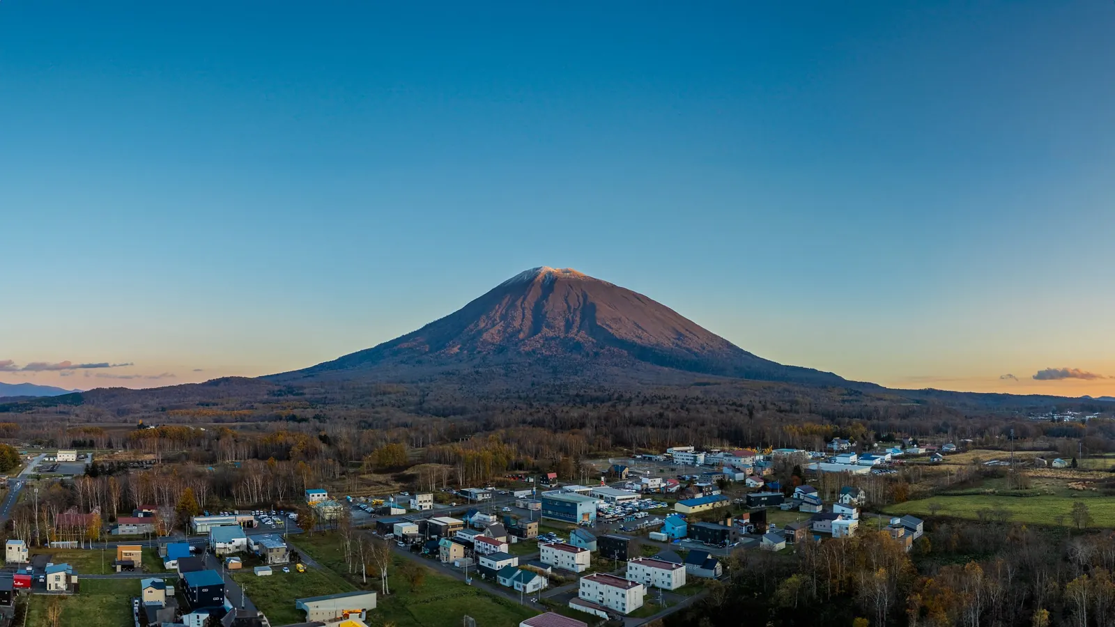 Drone photograph of Kutchan town with Mount Yotei at dusk