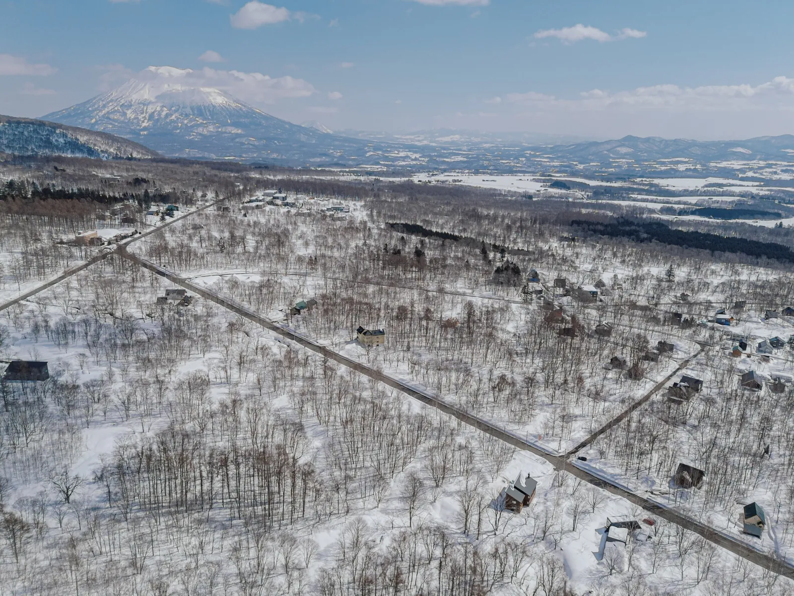 Aerial drone view over snow covered forest and farmland near Niseko, Hokkaido