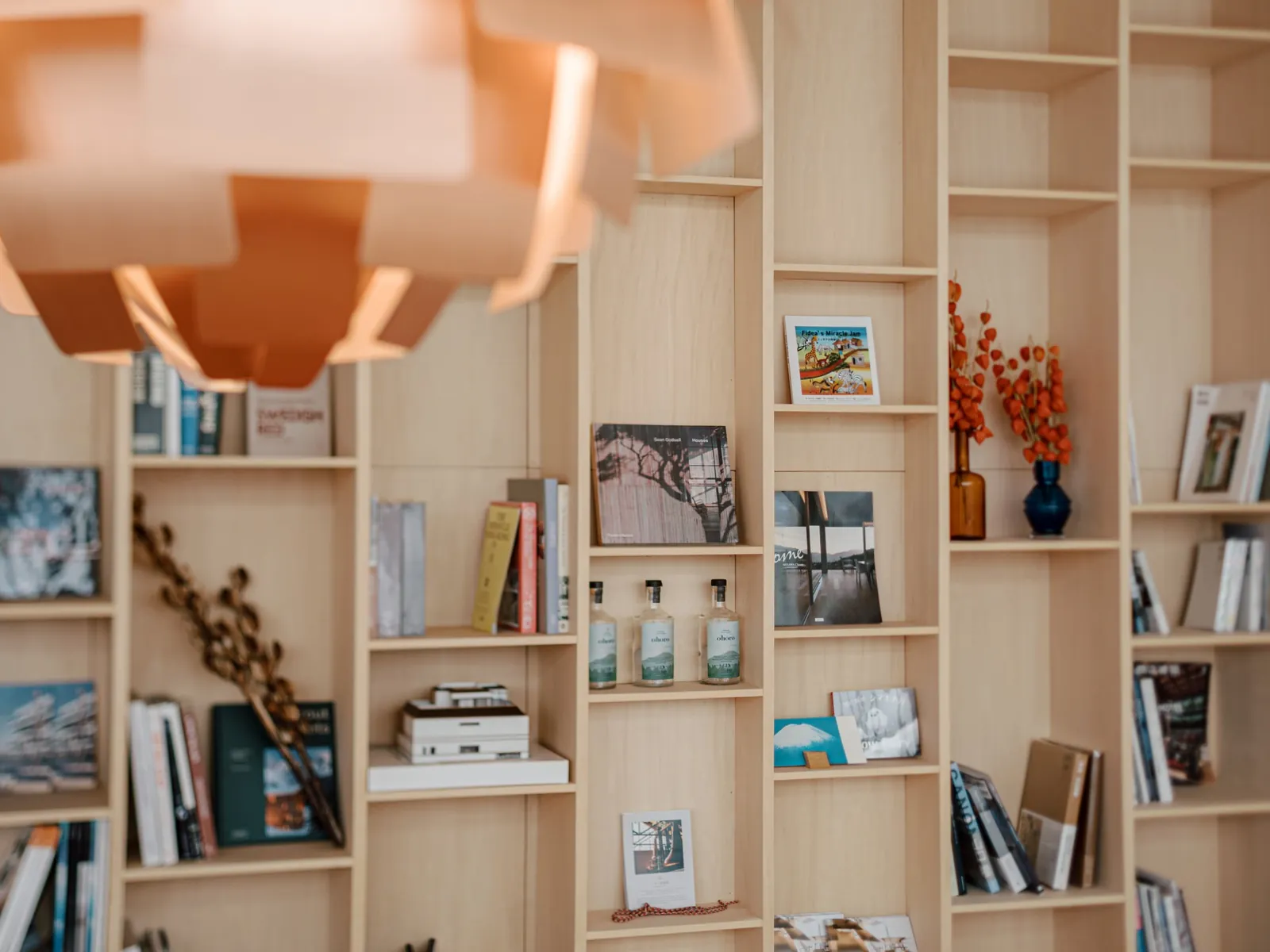 Plywood bookshelves under a copper pendant light at AK Housing, Niseko