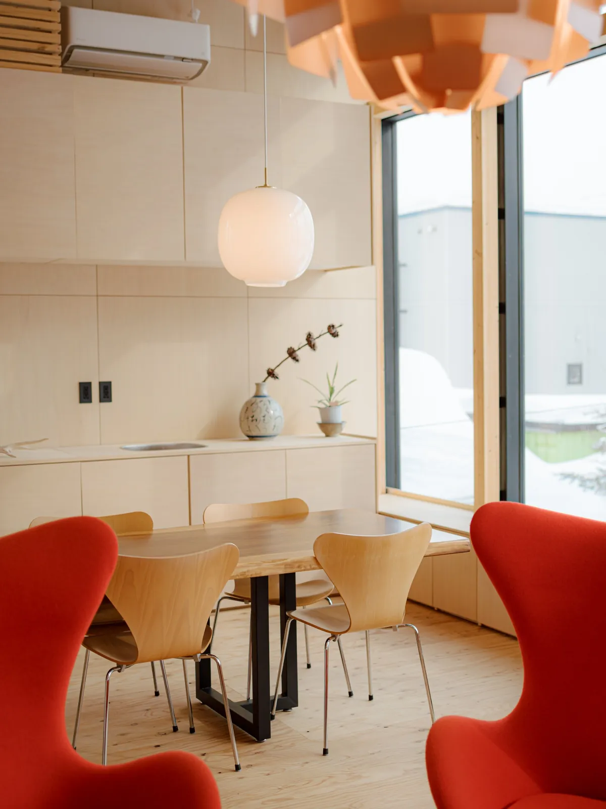 Dining corner with pendant lights and red chairs, AK Housing, Niseko