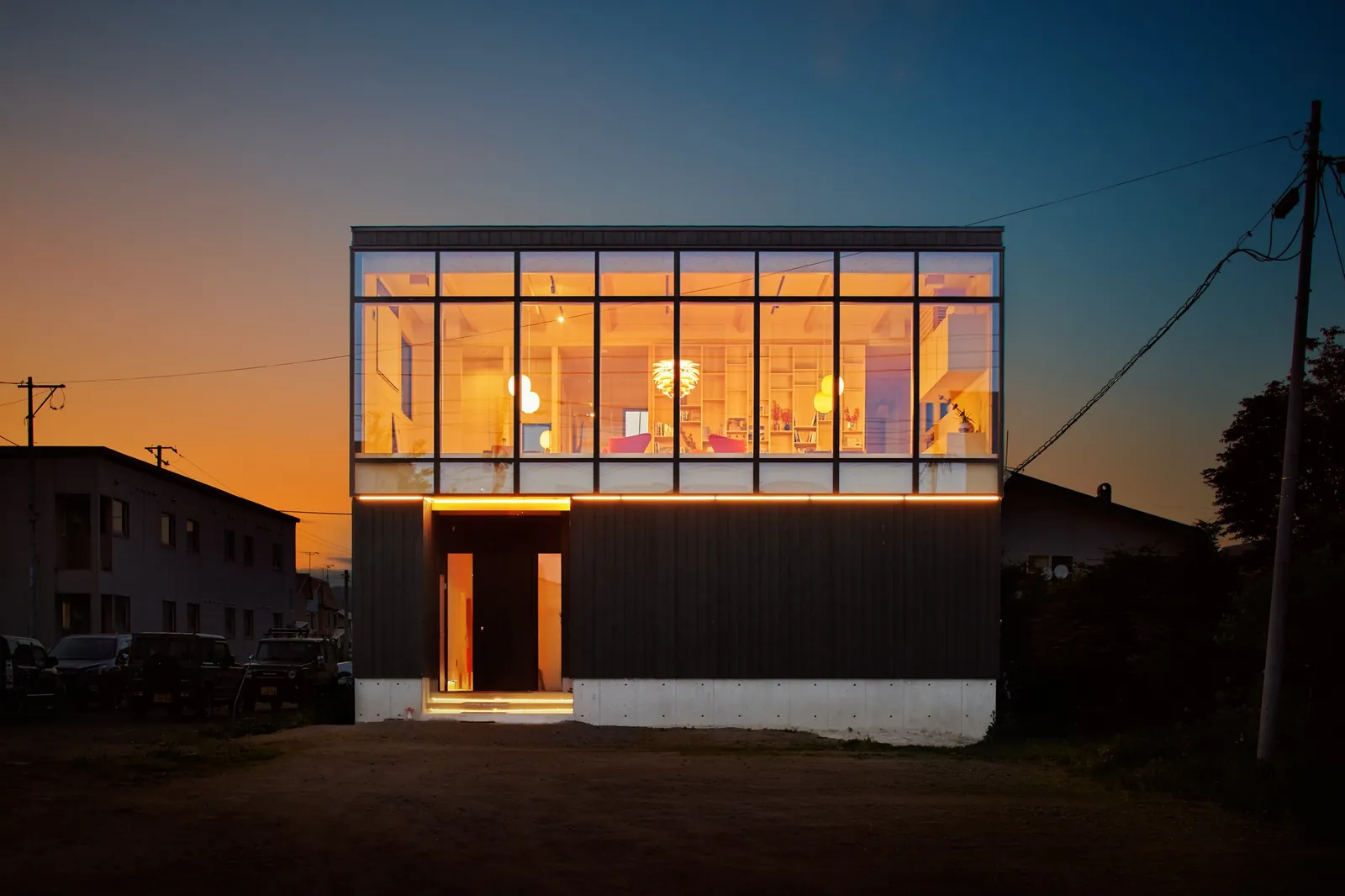 AK Housing office glazed facade lit at dusk, Niseko