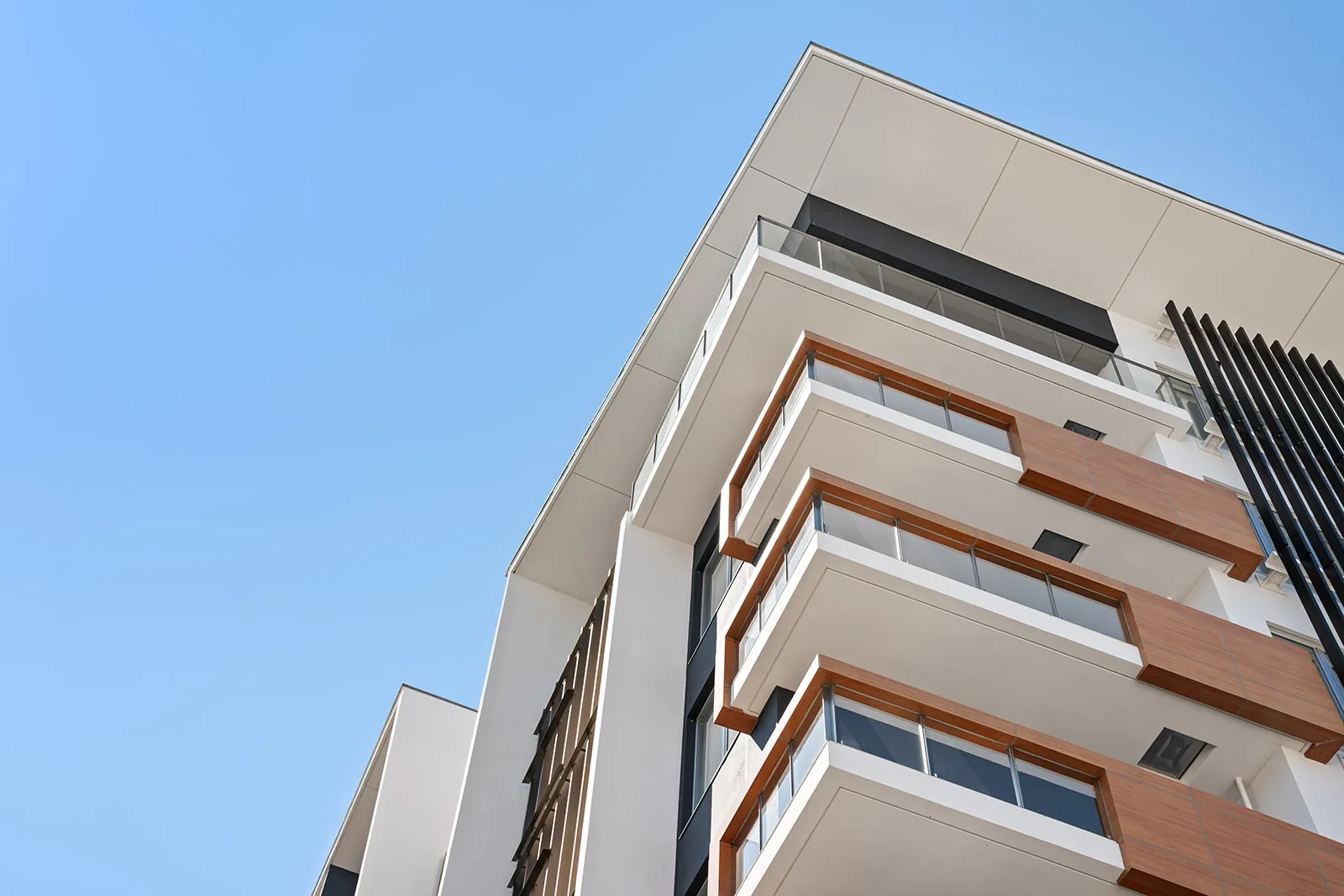 Alpen Ridge Hotel Niseko balconies with timber accents against a blue sky