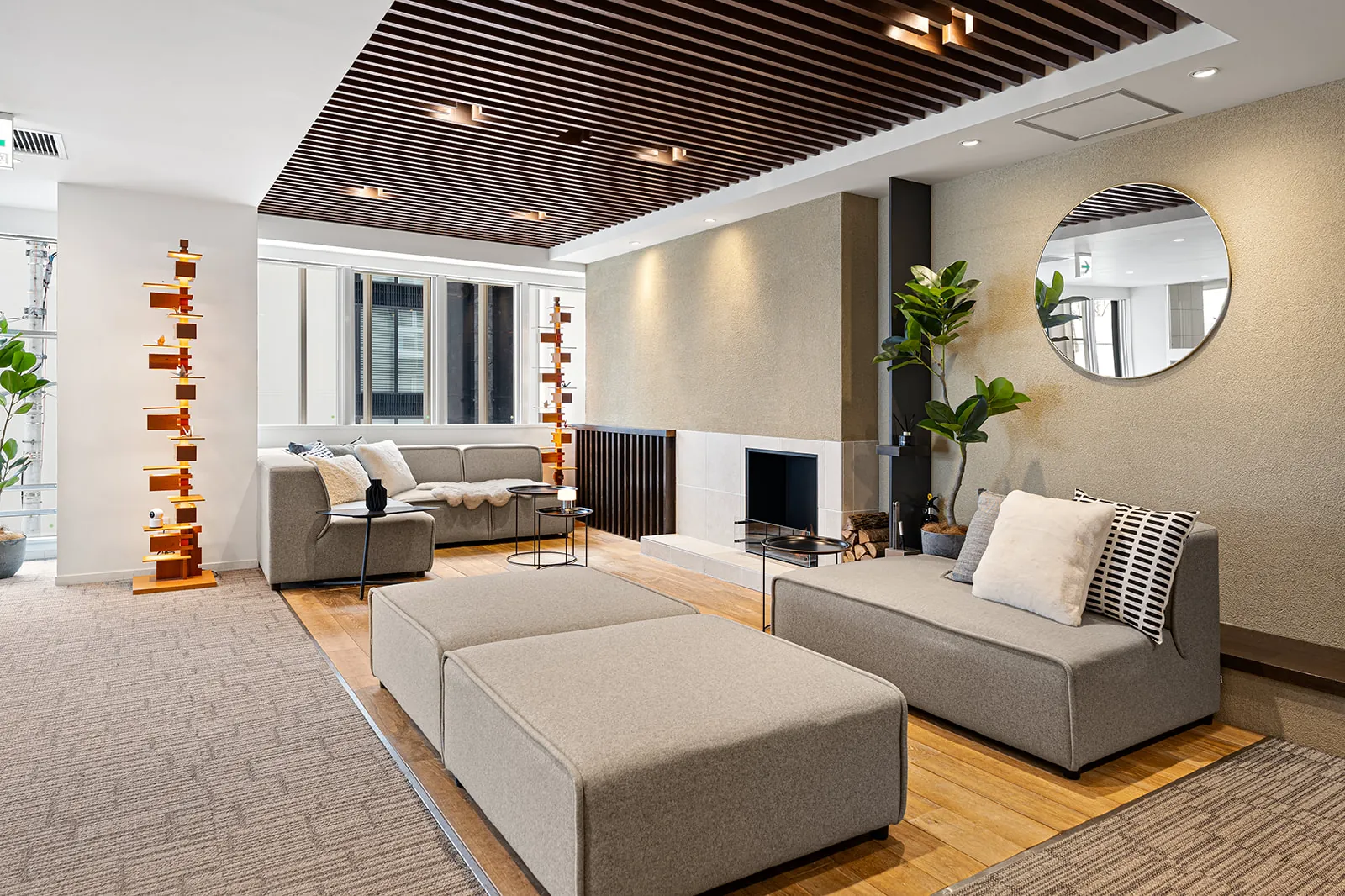Alpen Ridge Hotel Niseko lobby lounge with a timber slat ceiling, sofas and a round mirror