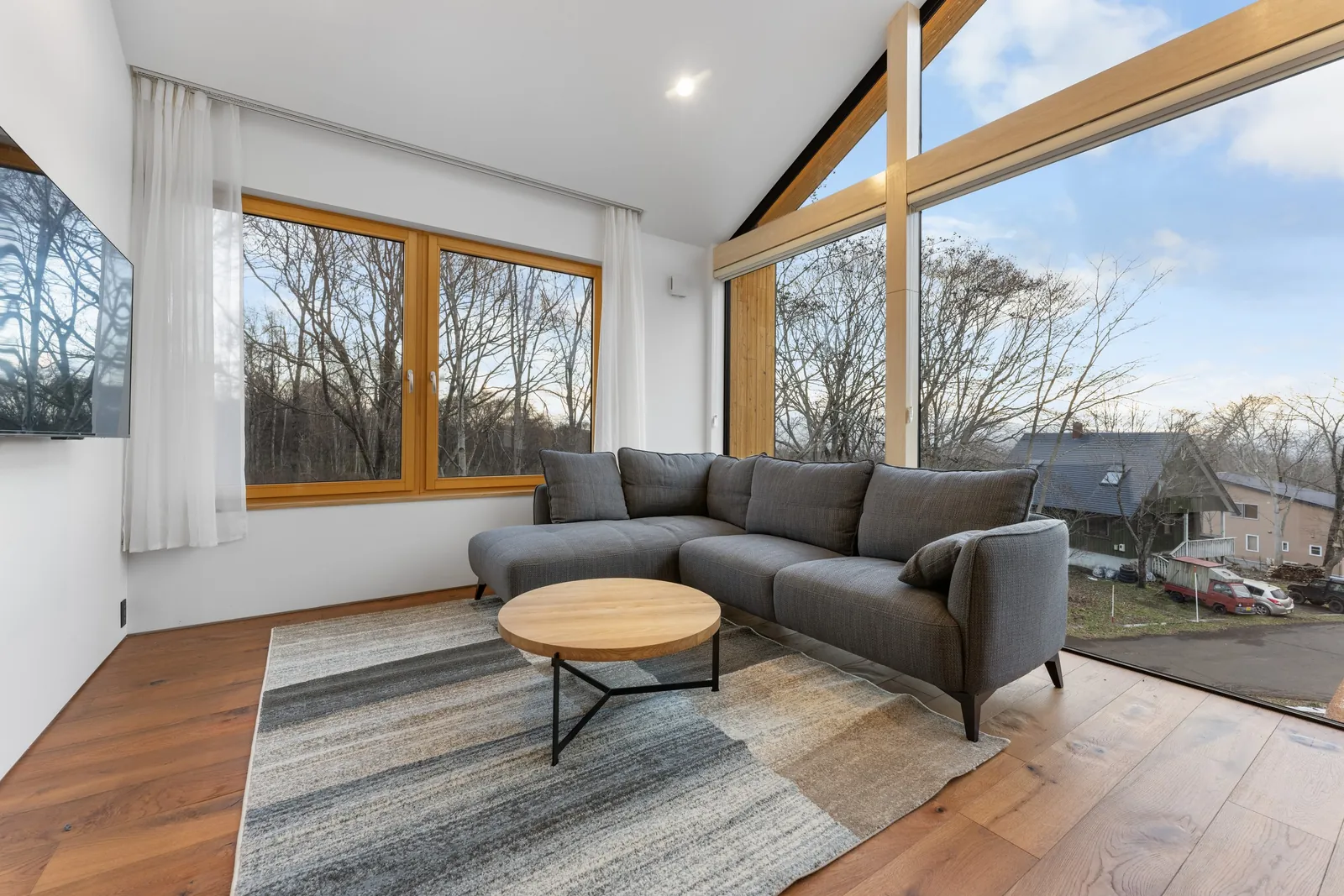 Living room with tall gable windows at Aoyama Villa Niseko