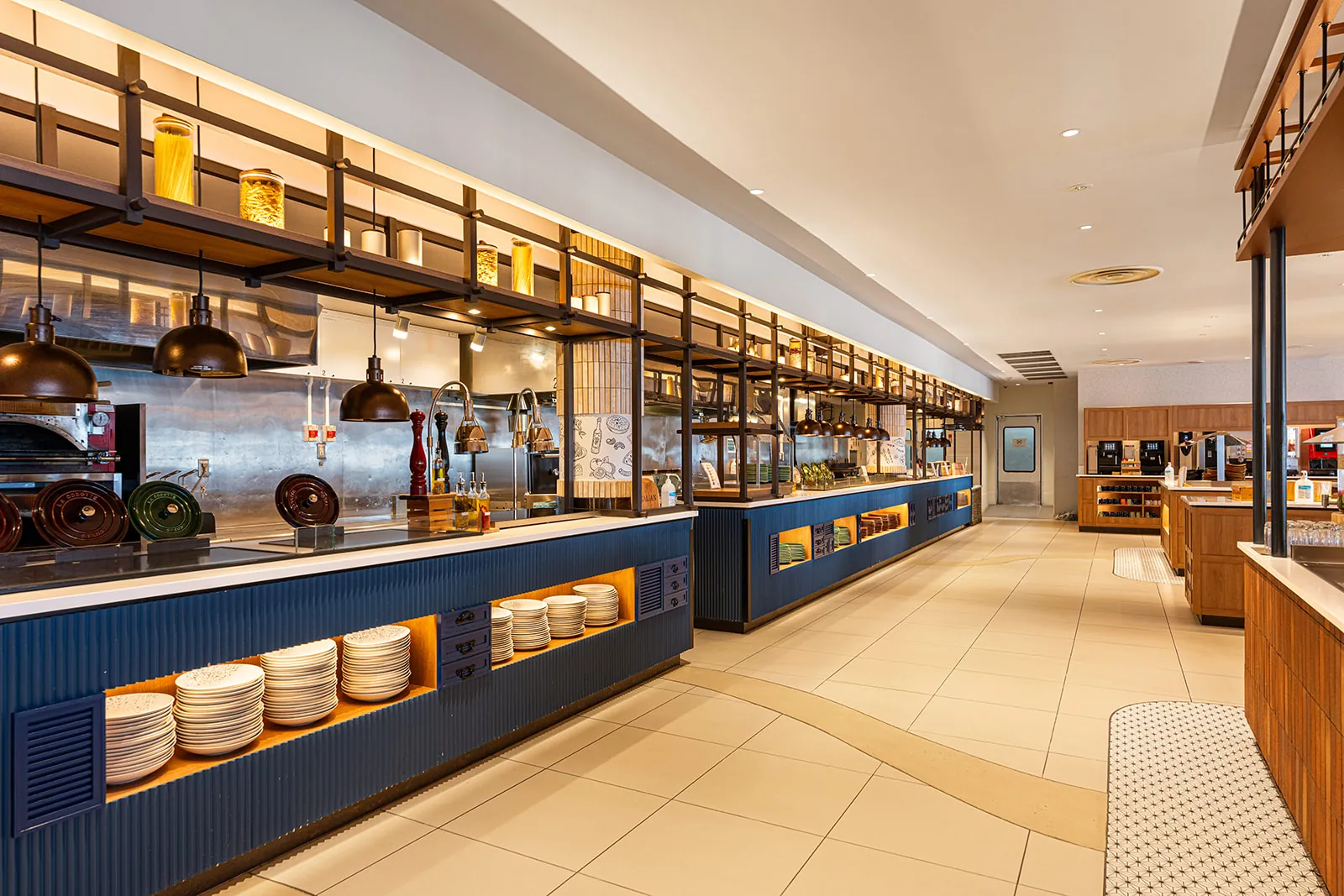Open kitchen counter with a blue tiled base and copper pendants in the Daichi restaurant, Club Med Sahoro