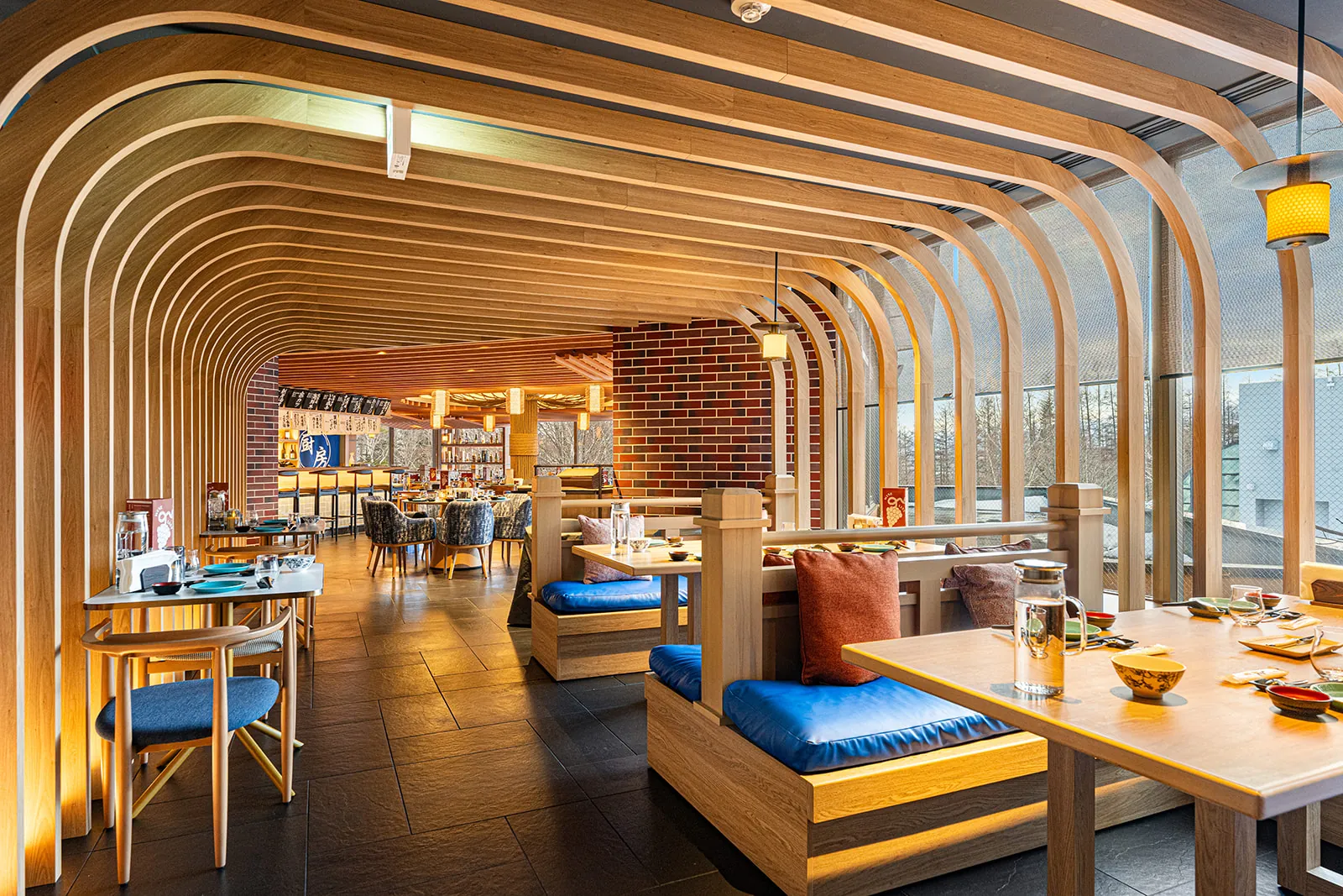 Booth seating under curved timber arches in the Mina Mina restaurant, Club Med Sahoro