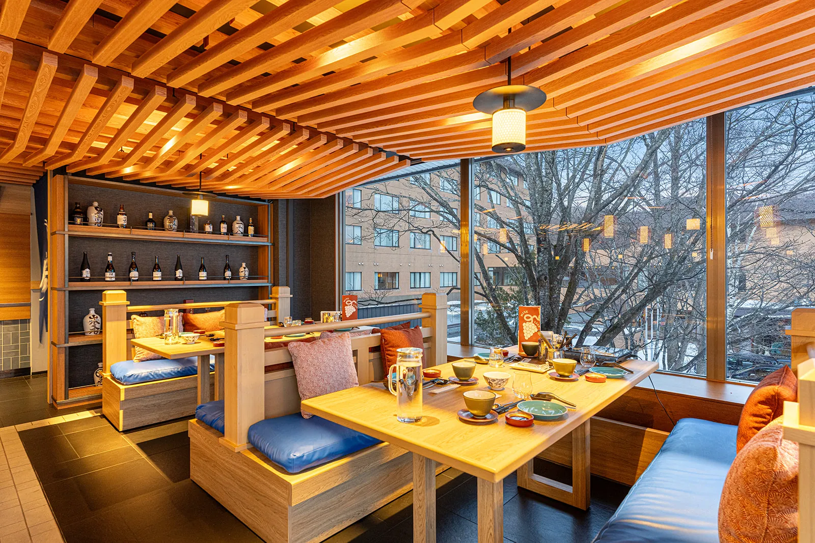 Window booth with blue cushions and sake shelving in Mina Mina, Club Med Sahoro