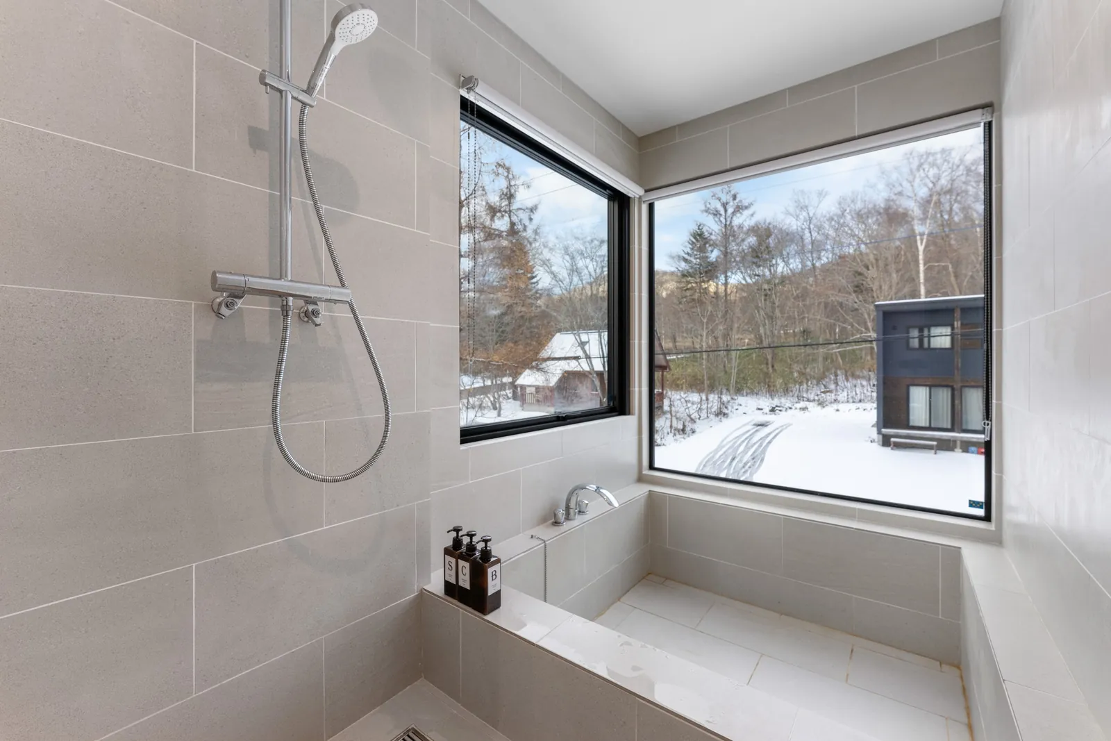 Bath with snowy window view at Dreamlife Niseko