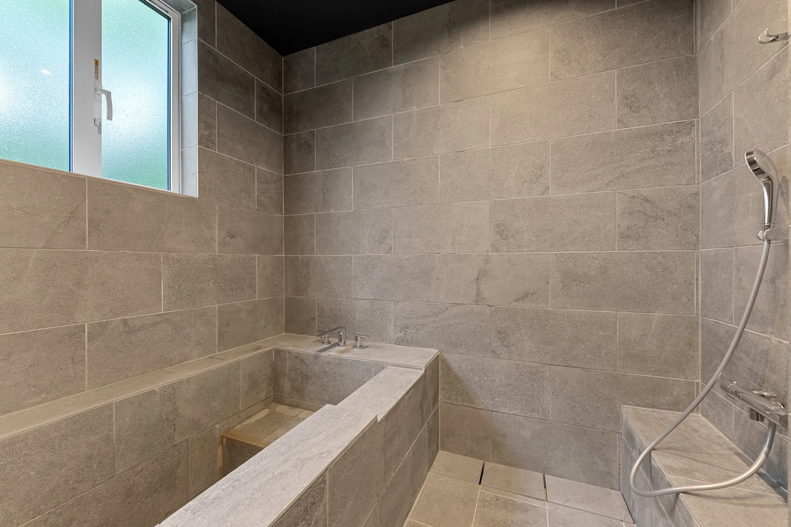Stone tiled bathroom with sunken tub at Hanazaki Royal Town