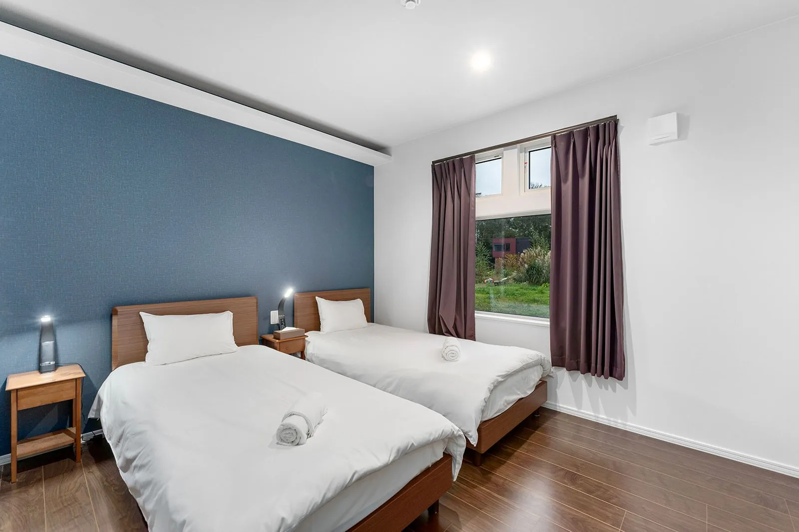 Twin bedroom with blue feature wall at Hikari House