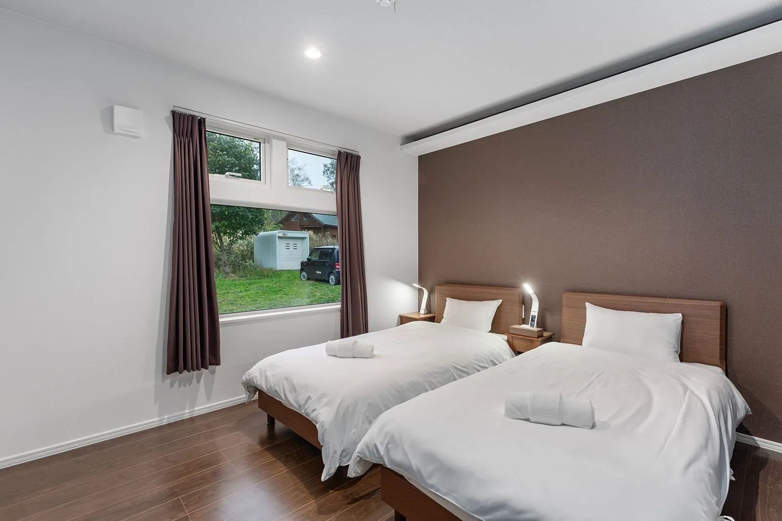 Twin bedroom with brown feature wall at Hikari House