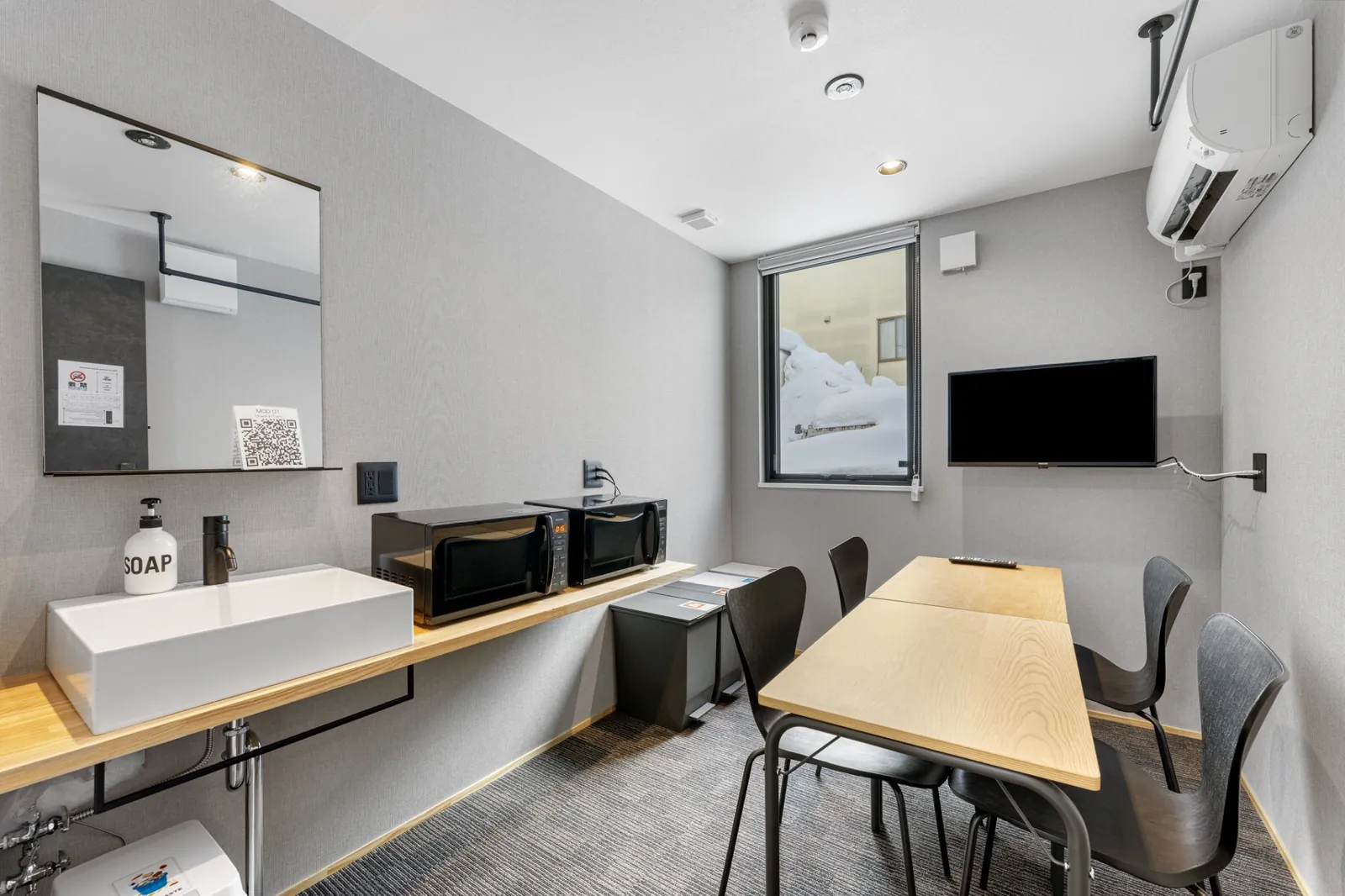 MOD Kutchan room with desk, basin and wall mounted TV