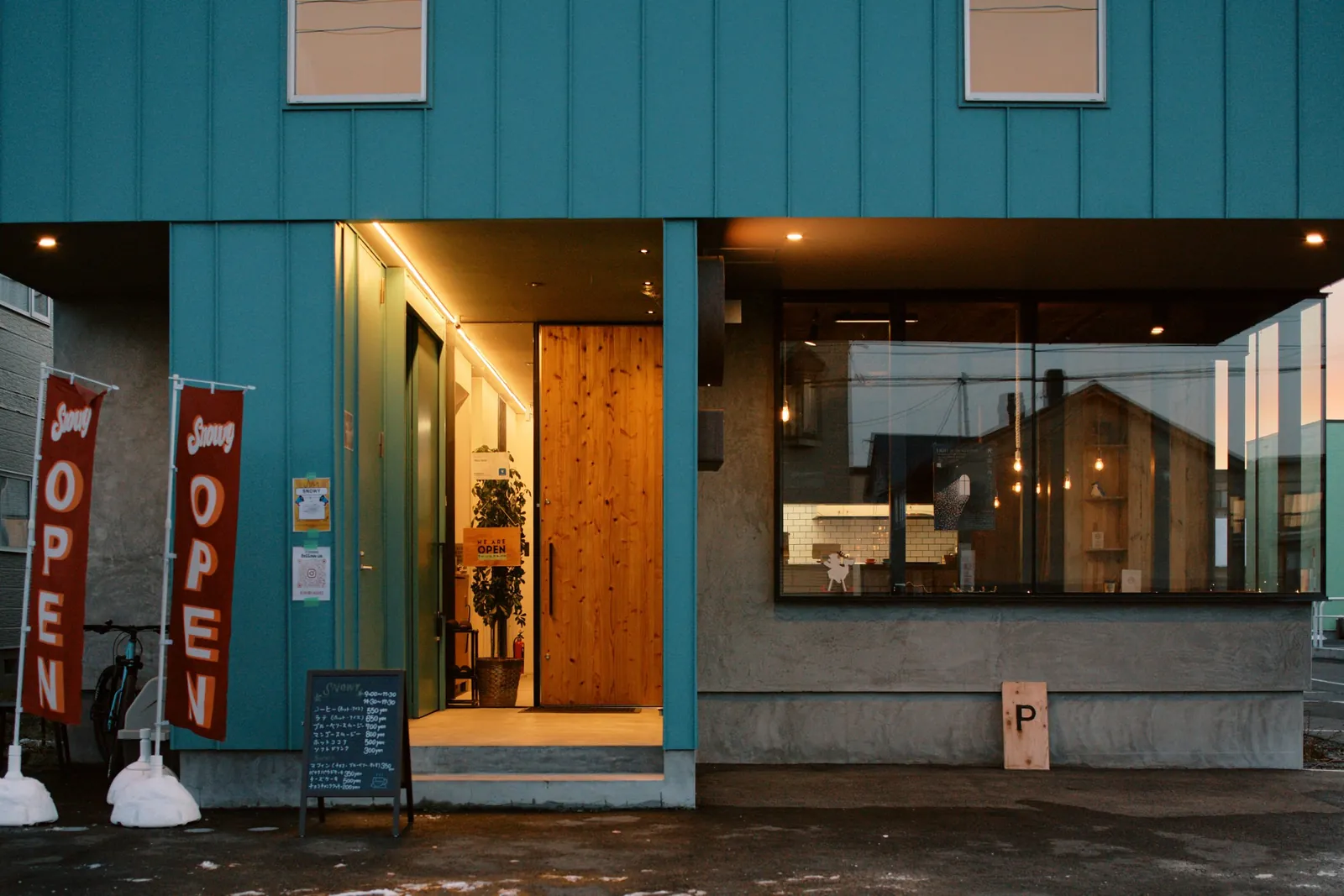 Snowy Cafe Niseko entrance with open flags
